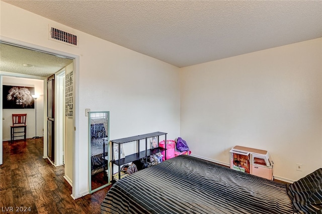 bedroom featuring dark wood-type flooring and a textured ceiling