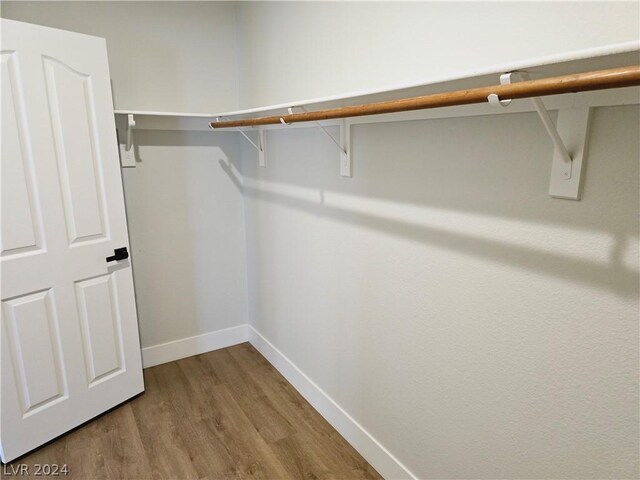 walk in closet with wood-type flooring