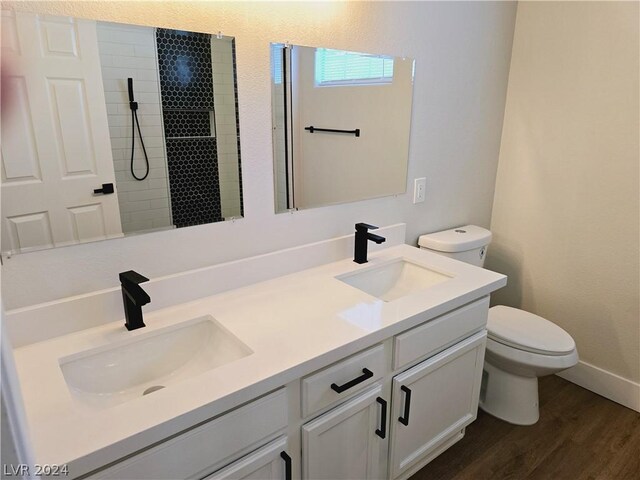 bathroom featuring vanity, toilet, hardwood / wood-style floors, and a shower