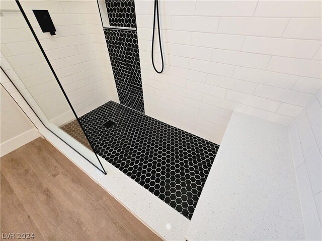 details featuring a tile shower and hardwood / wood-style floors