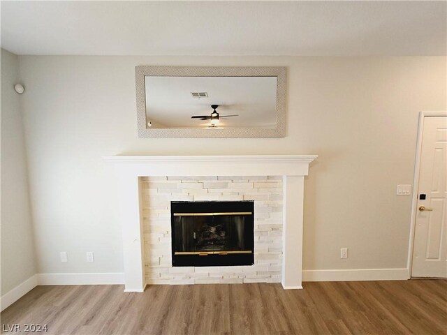 room details featuring ceiling fan, a fireplace, and hardwood / wood-style floors