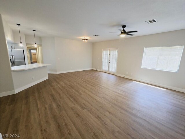 unfurnished living room with dark hardwood / wood-style flooring, ceiling fan, and a healthy amount of sunlight