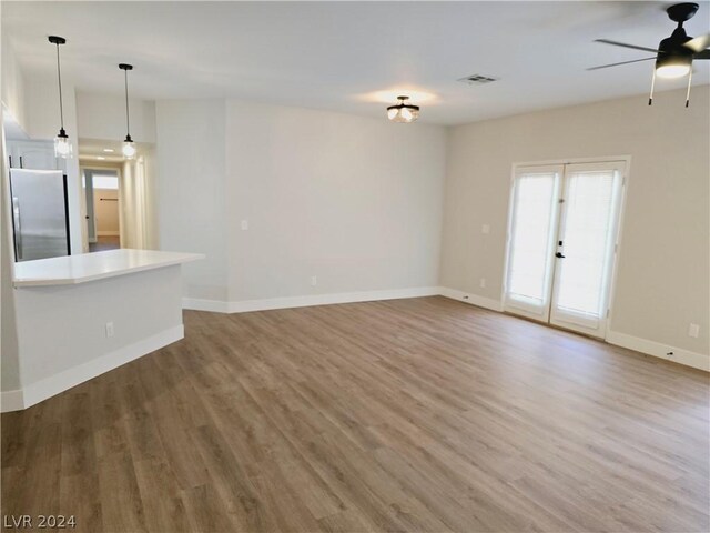 unfurnished living room with ceiling fan and wood-type flooring