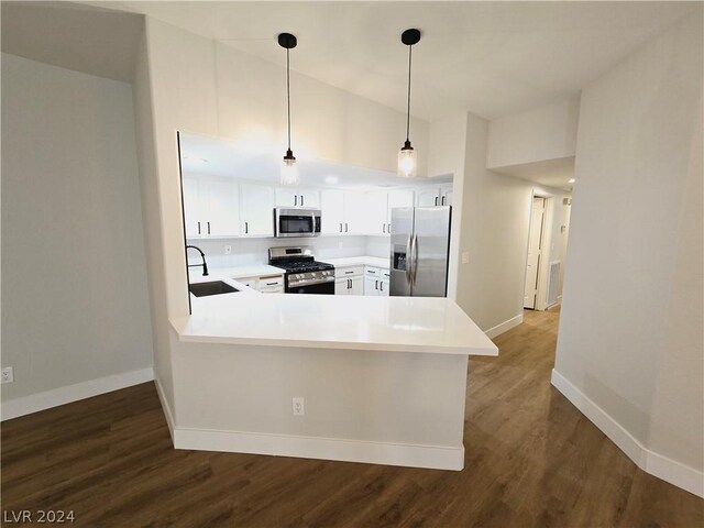 kitchen with appliances with stainless steel finishes, sink, pendant lighting, and kitchen peninsula