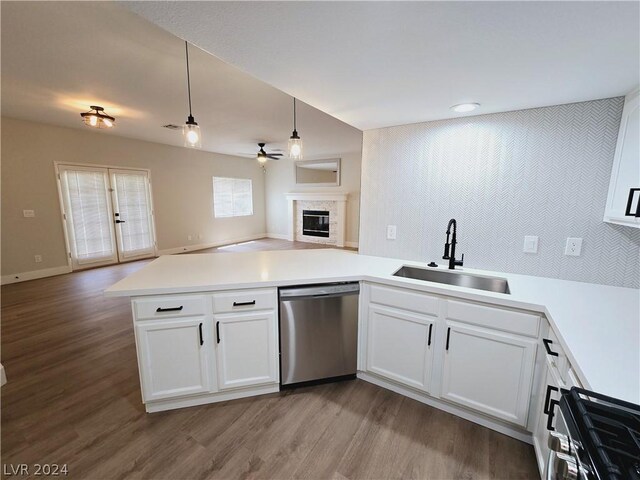 kitchen featuring sink, stainless steel dishwasher, kitchen peninsula, and white cabinets