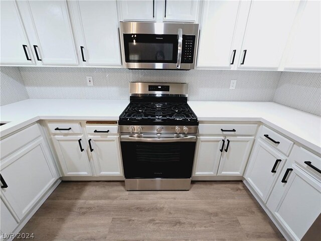 kitchen with white cabinetry, appliances with stainless steel finishes, and light wood-type flooring