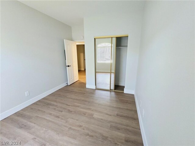 unfurnished bedroom with light hardwood / wood-style flooring and a closet