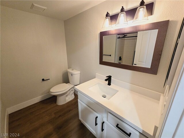 bathroom featuring vanity, hardwood / wood-style floors, and toilet