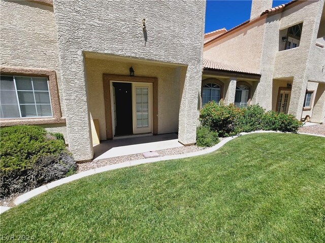 view of exterior entry with a lawn