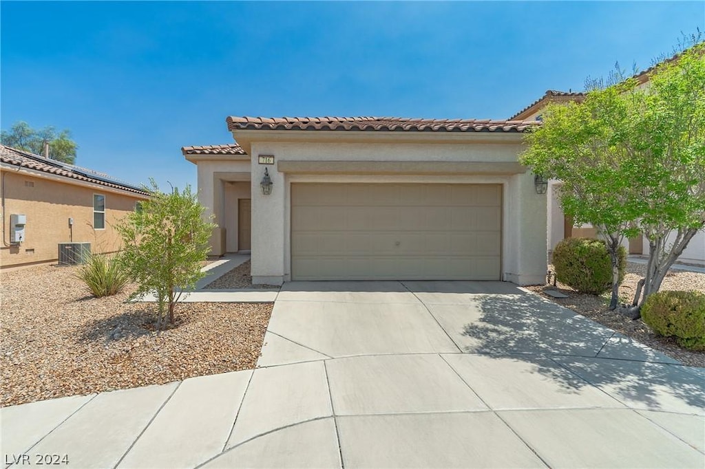 mediterranean / spanish home featuring a garage and central AC unit