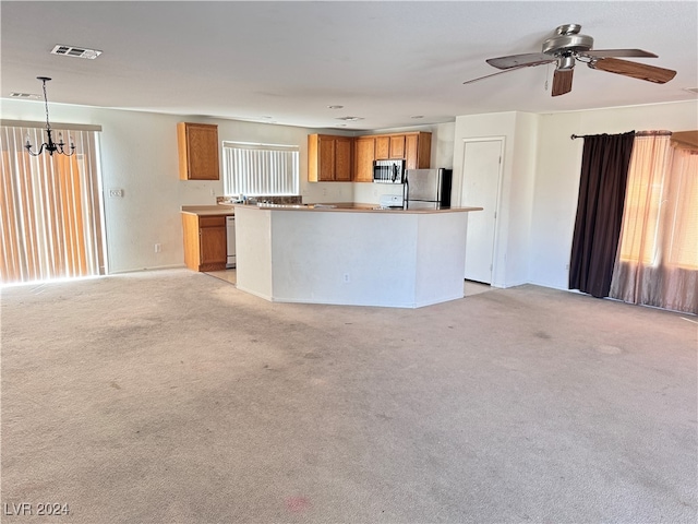 kitchen with ceiling fan with notable chandelier, a center island, light colored carpet, and stainless steel appliances