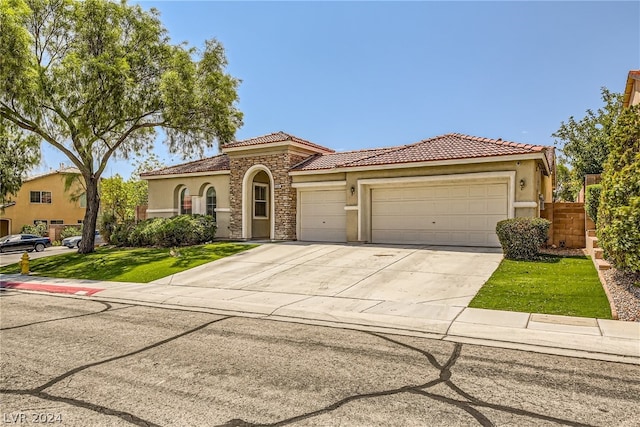 1505 Barrington Oaks St, North Las Vegas, NV 89084 - mediterranean / spanish-style home featuring stucco siding, a garage, driveway, a tiled roof, and stone siding