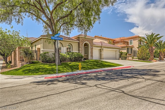 1505 Barrington Oaks St, North Las Vegas, NV 89084 - mediterranean / spanish-style house featuring stucco siding, a garage, concrete driveway, a tiled roof, and stone siding