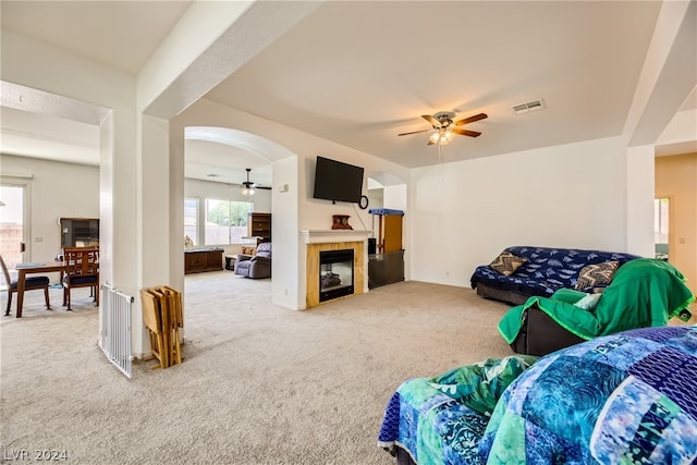1505 Barrington Oaks St, North Las Vegas, NV 89084 - carpeted living area featuring a ceiling fan, arched walkways, and a tile fireplace