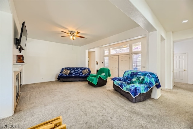 living area with light carpet and ceiling fan