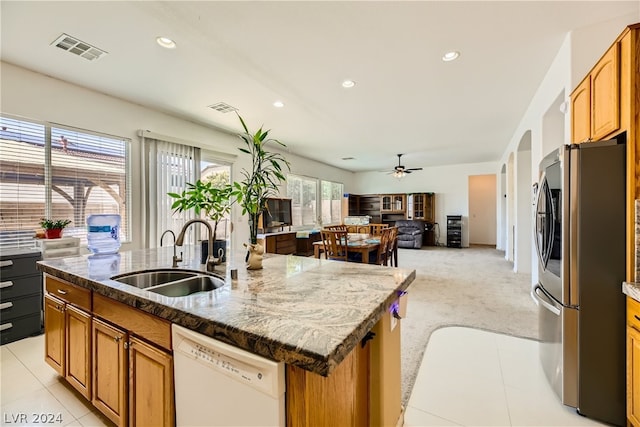 kitchen featuring sink, a kitchen island with sink, stainless steel refrigerator with ice dispenser, dishwasher, and ceiling fan