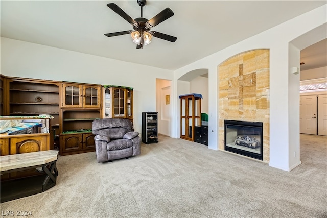 carpeted bedroom featuring ensuite bathroom, a tile fireplace, and ceiling fan