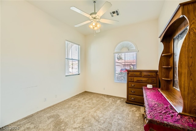 bedroom featuring multiple windows, light colored carpet, and ceiling fan