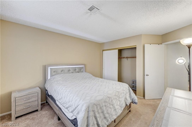 bedroom with light carpet, a textured ceiling, and a closet