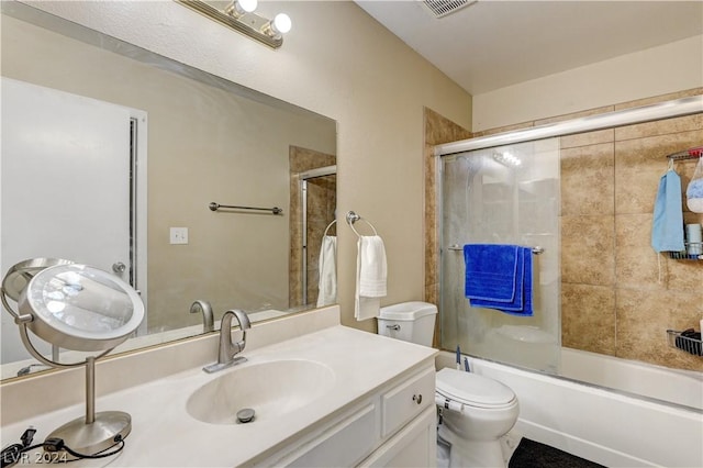 full bathroom featuring toilet, vanity, and shower / bath combination with glass door