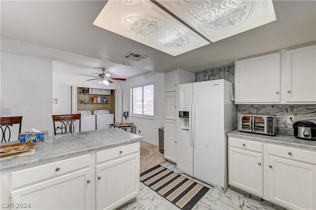 kitchen with washer and dryer, tasteful backsplash, white cabinets, white refrigerator with ice dispenser, and ceiling fan