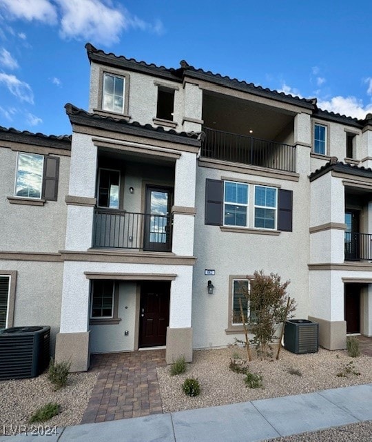 view of front of property with a balcony and central AC