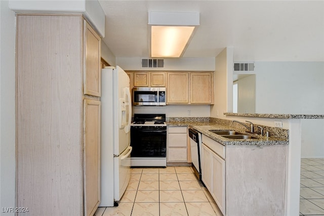 kitchen with range with gas stovetop, light brown cabinetry, dishwasher, sink, and white fridge