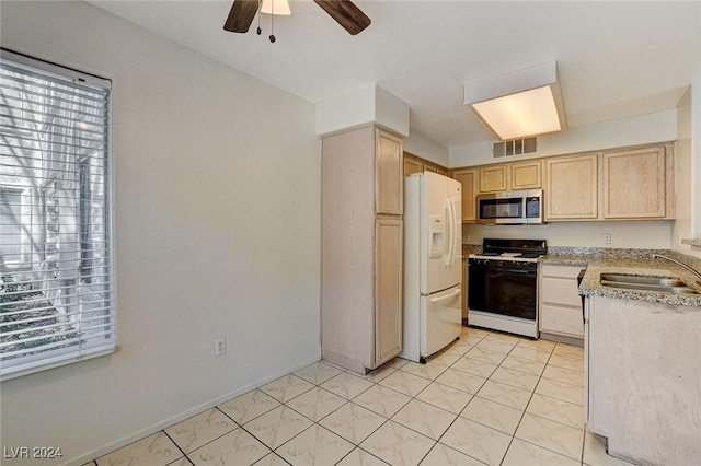 kitchen with sink, ceiling fan, white fridge with ice dispenser, gas stove, and light brown cabinets