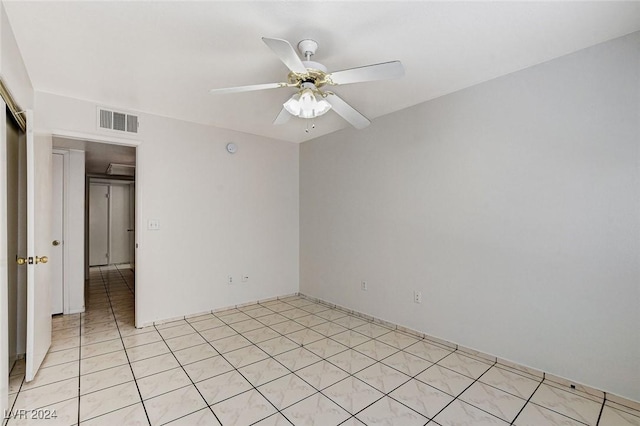 empty room with ceiling fan and light tile patterned flooring