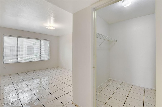 walk in closet with light tile patterned floors