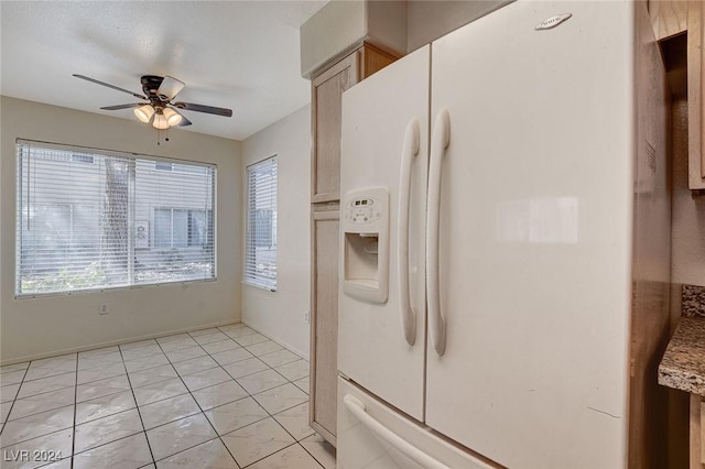 kitchen featuring a wealth of natural light, white fridge with ice dispenser, ceiling fan, and light tile patterned flooring