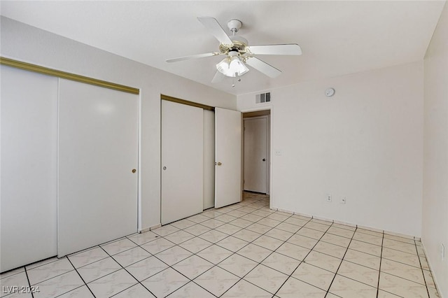 unfurnished bedroom featuring two closets and ceiling fan