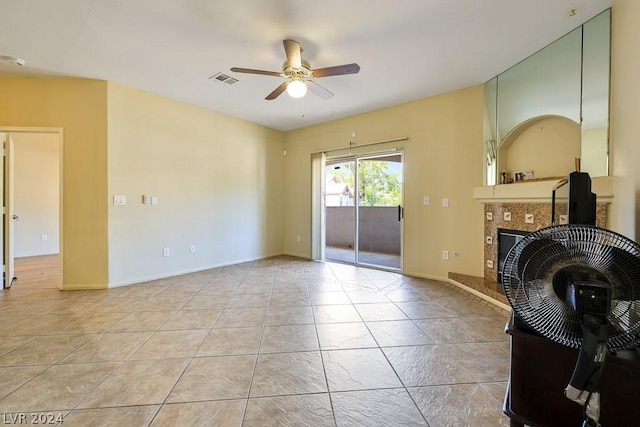 living room with ceiling fan and a tile fireplace