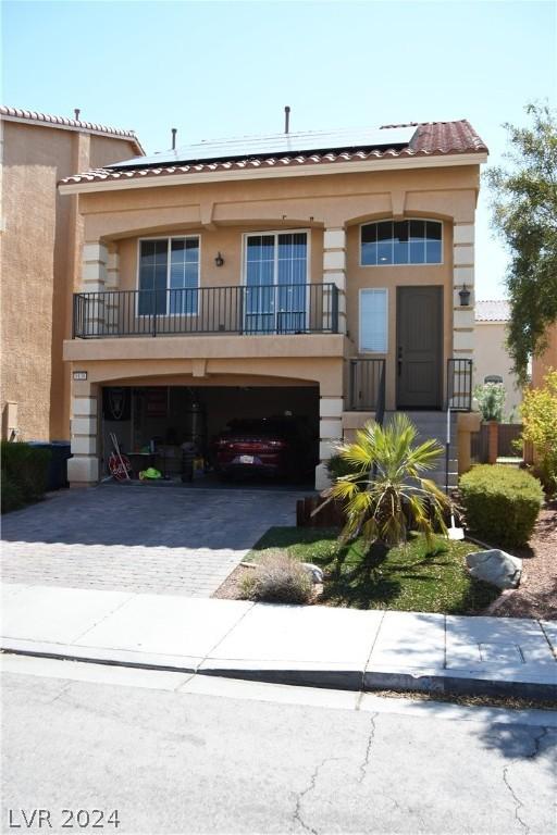 view of front of house featuring a garage and a balcony