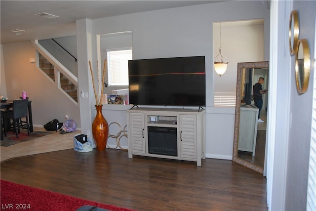 living room featuring a fireplace and dark wood-type flooring