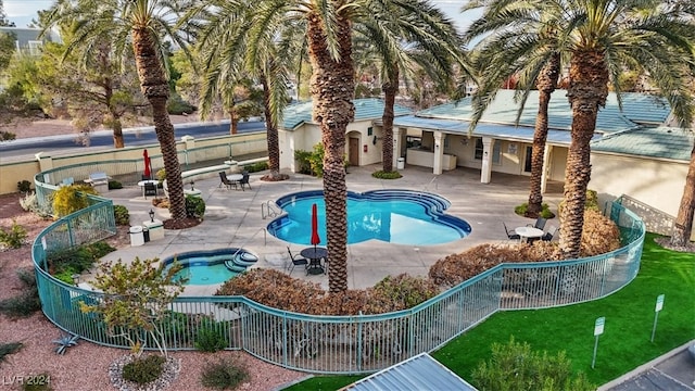 view of swimming pool featuring a patio and a hot tub