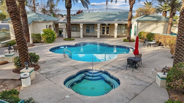 view of pool featuring a patio area and an in ground hot tub