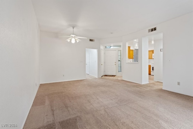 unfurnished living room featuring light carpet and ceiling fan