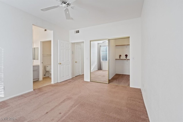 unfurnished bedroom featuring ceiling fan, light colored carpet, and connected bathroom