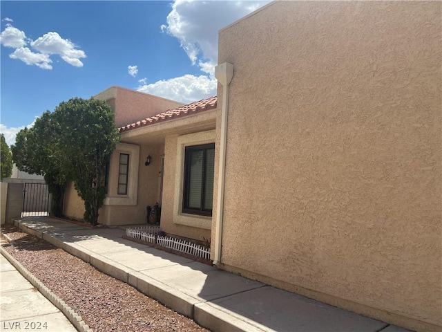 view of property exterior with stucco siding and a tiled roof