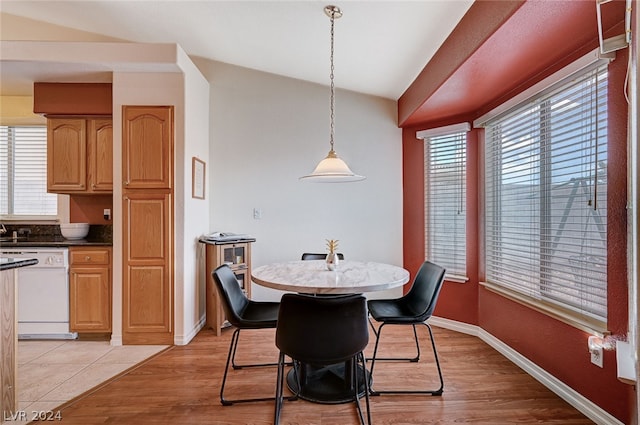 dining room featuring lofted ceiling and light hardwood / wood-style flooring