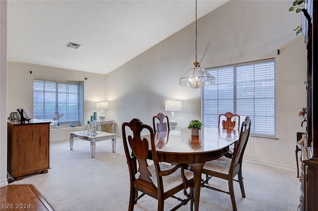 carpeted dining room featuring vaulted ceiling and an inviting chandelier