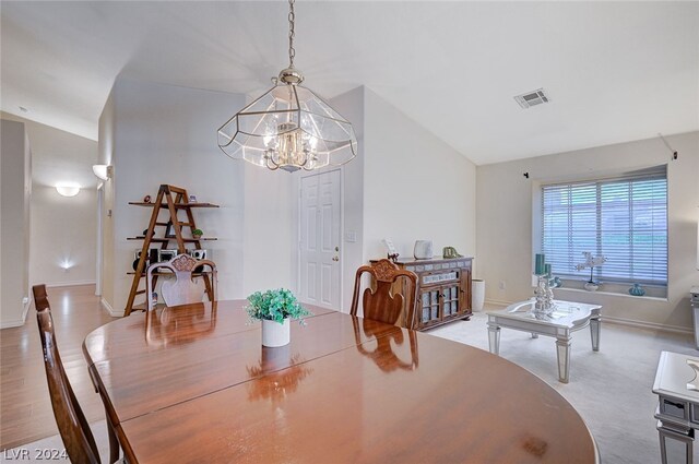 dining area with light carpet and a chandelier