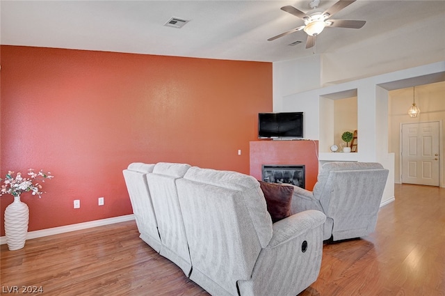 living room featuring hardwood / wood-style flooring, vaulted ceiling, and ceiling fan