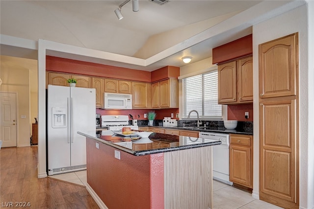 kitchen with rail lighting, light wood-type flooring, white appliances, sink, and a kitchen island