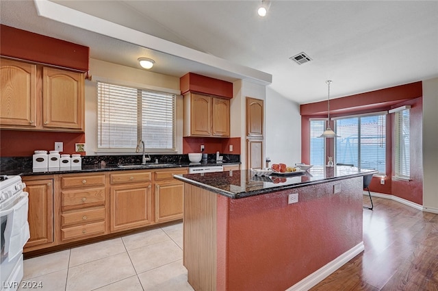 kitchen featuring pendant lighting, a center island, a healthy amount of sunlight, and light tile patterned floors