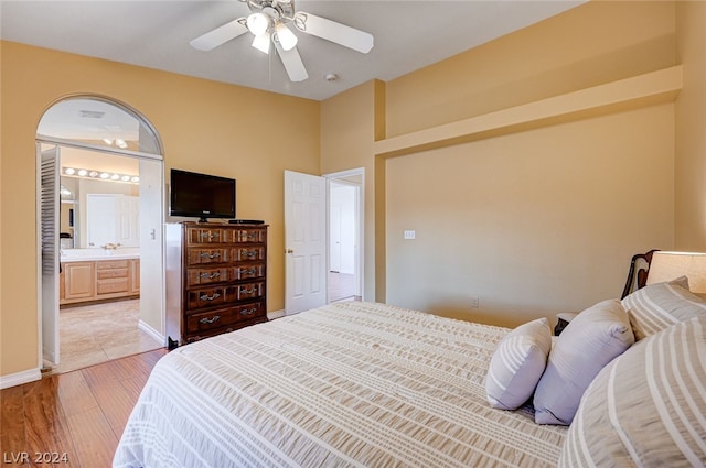 bedroom featuring light hardwood / wood-style flooring, ensuite bath, and ceiling fan