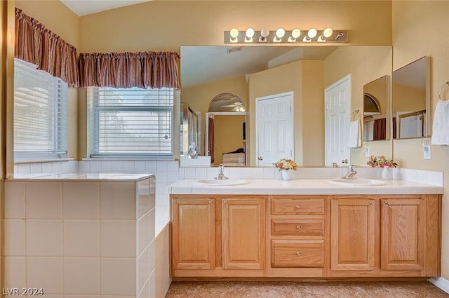 bathroom with double sink vanity and vaulted ceiling