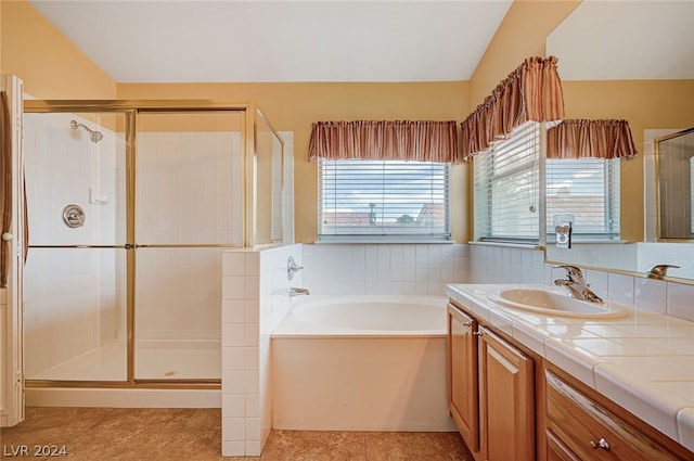 bathroom featuring independent shower and bath, vanity, and tile patterned flooring