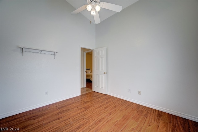 empty room featuring high vaulted ceiling, ceiling fan, and hardwood / wood-style floors